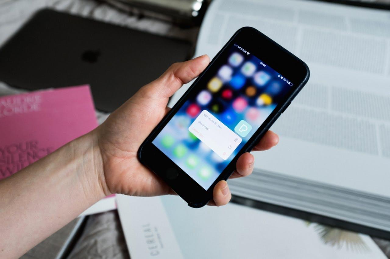 Рука человека настраивает меню смартфона